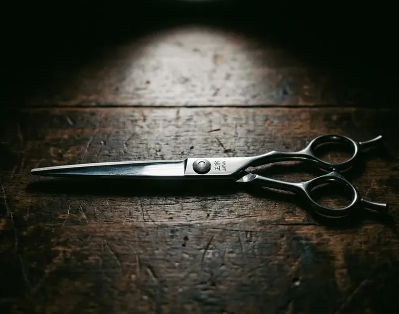 Premium cutting shear on dark wood with dramatic spotlight