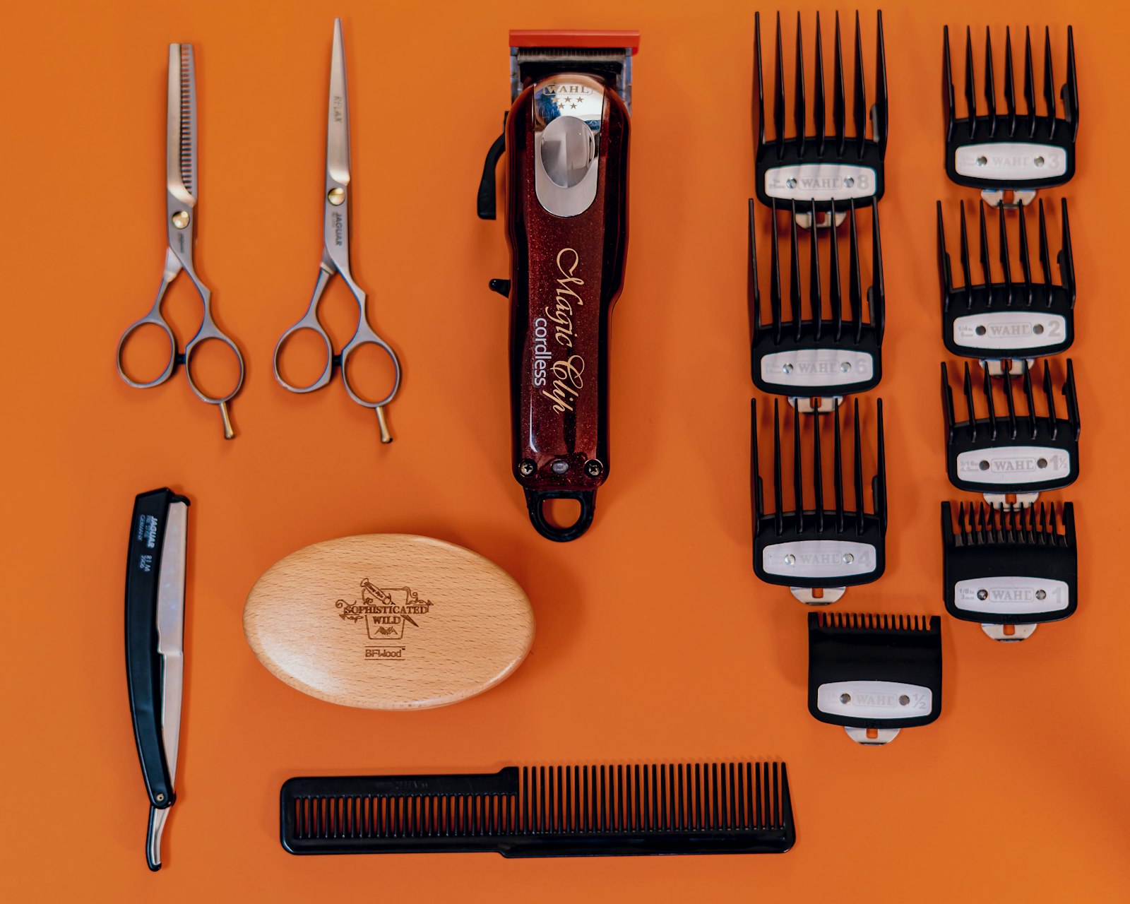 Polished barber shears resting across a comb on a workbench