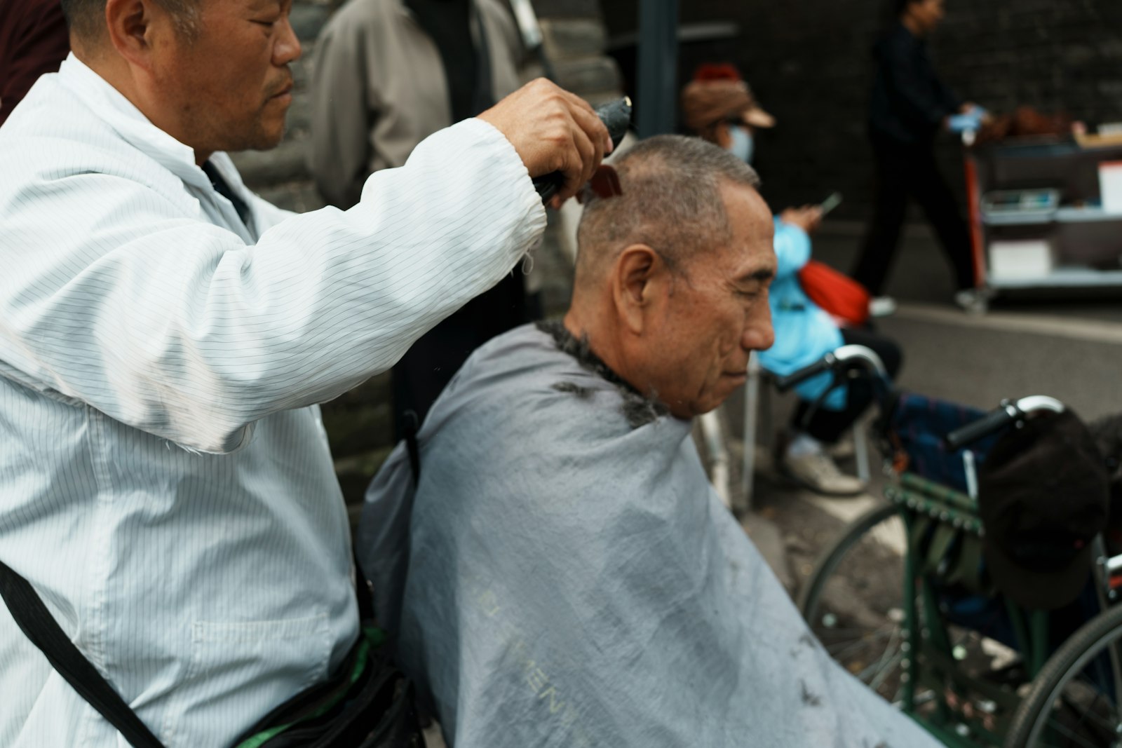 Mobile barber delivering a haircut outdoors